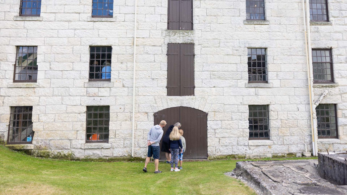 A family looking at the outside of the mill building.