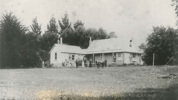 Historic black and white photo of Hurworth farm with people and a horse out the front.