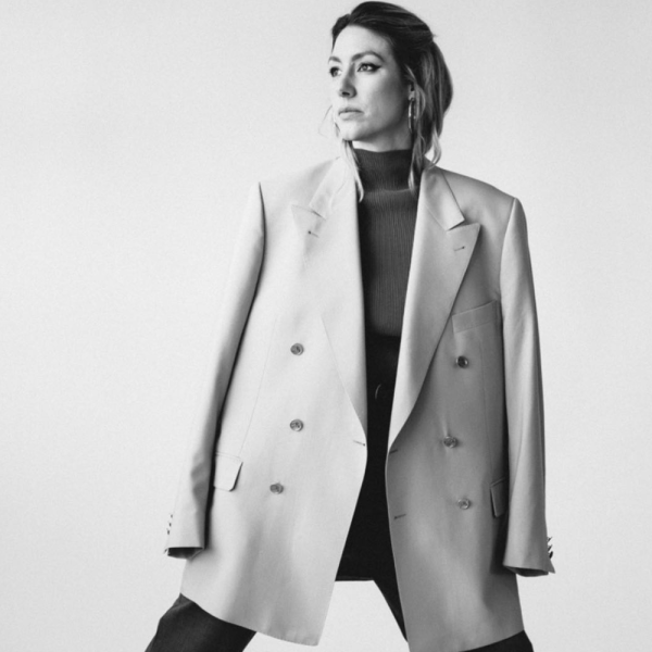 Black and white image of a woman in an oversized suit jacket.