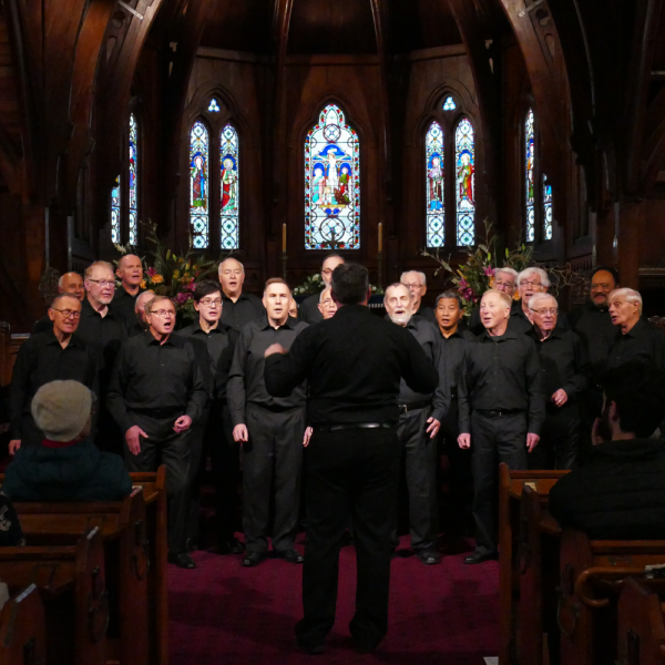 Men in black singing in church.