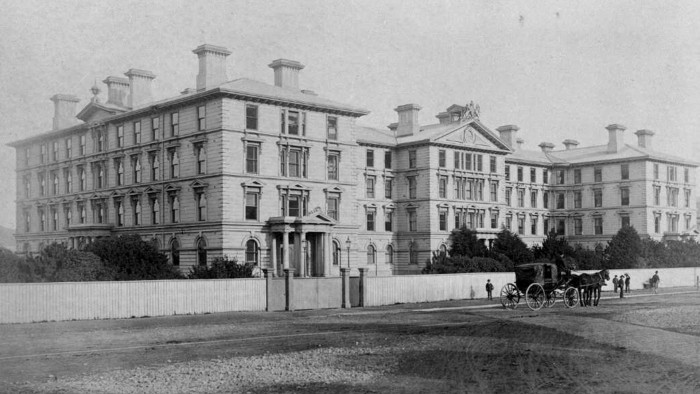 Historic black and white photo of Old Government Buildings with people out the front, circa 1880-90s