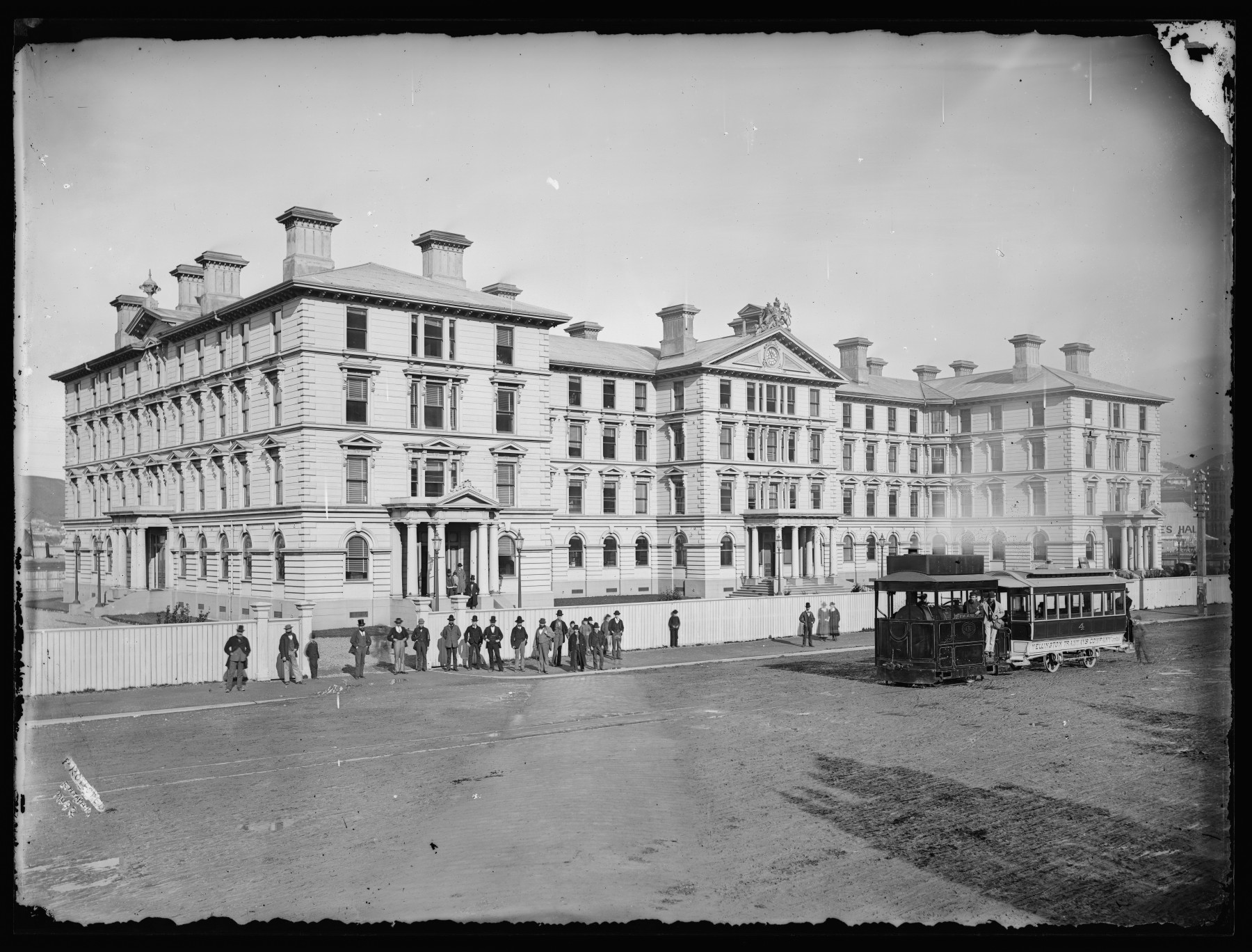 Black and white photo of Old Government Buildings with a tram in the foreground.