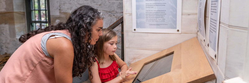 Mother and daughter using touch screen at Kerikeri Mission Station